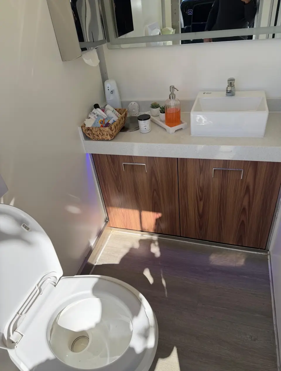 Wood vanity and vessel sink inside a restroom trailer