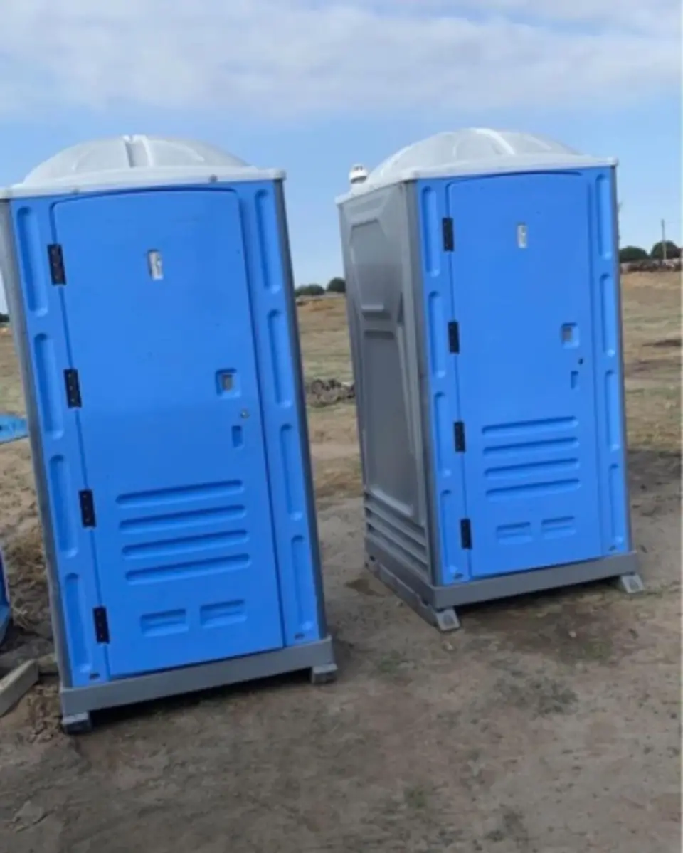 Two clean blue standard porta potties ready for delivery